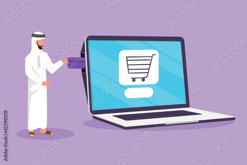 Cartoon flat style drawing young Arabian man inserting credit card into large laptop screen with shopping cart inside. E-commerce, digital payment and online store. Graphic design vector illustration