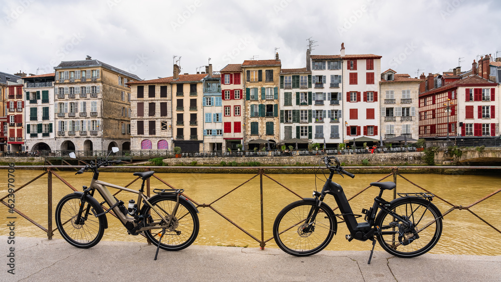Electric bikes parked by the river in the old city of Bayonne in southern France.