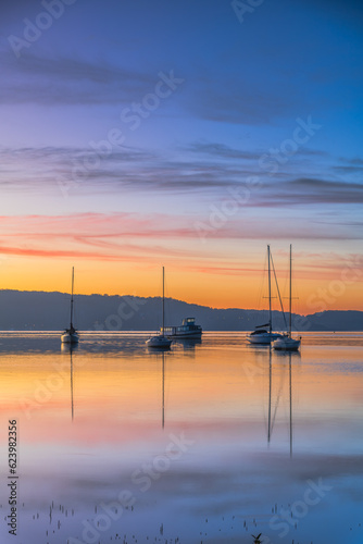 Beautiful sunrise waterscape with high cloud  reflections and boats