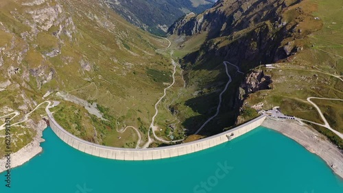Moiry, Switzerland: Aerial drone footage of the Moiry dam above the Grimentz village in the Anniviers valley in Canton Valais in the Swiss alps in summer. Shot with a backward motion.  photo