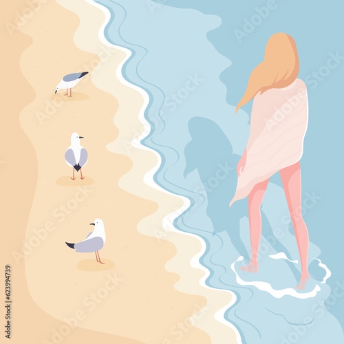Young girl with blonde hair walking along sandy beach.Calm summer landscape with seagulls on the shore and quiet waves.