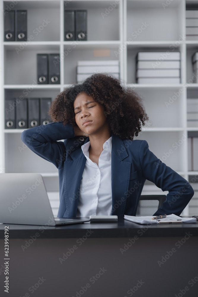 African American businesswoman are stressed and tired from work sitting at desk in the office, feeling sick at work, stress from work. African American businesswoman are stressed and tired from work sitting at desk in the office, feeling sick at work, stress from work.