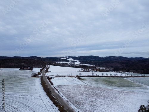Drone shot of snowy agricultural snowy fields in Bavaria on a cloudy day © helfei