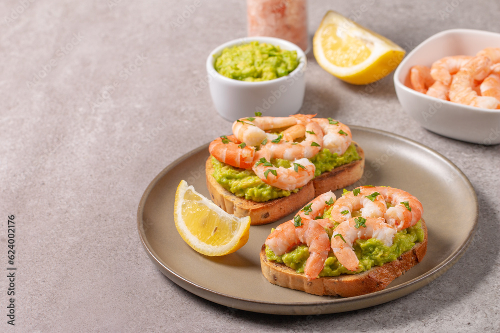 Appetizer toasted bruschetta with mashed avocado and shrimps on background. Healthy food concept with prawns. Appetizer toasted bruschetta with mashed avocado and shrimps on background. Healthy food concept with prawns.