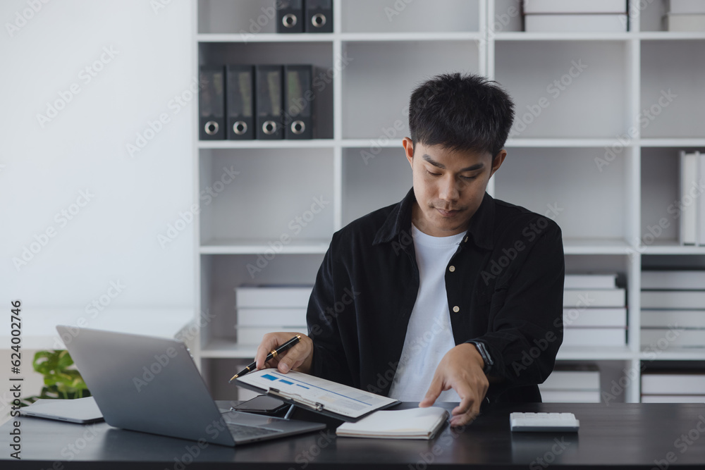 Asian businessman working online with laptop are stressed and tired from work sitting at desk in the office, feeling sick at work, stress from work. Asian businessman working online with laptop are stressed and tired from work sitting at desk in the office, feeling sick at work, stress from work.