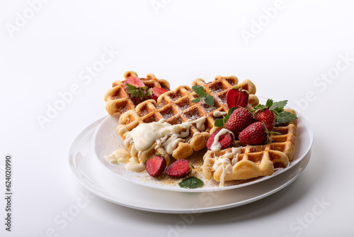 Viennese waffles with strawberries on a white dish on a light sunny background