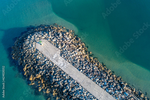 top view of a breakwater with the sea calm and the water turquoise.