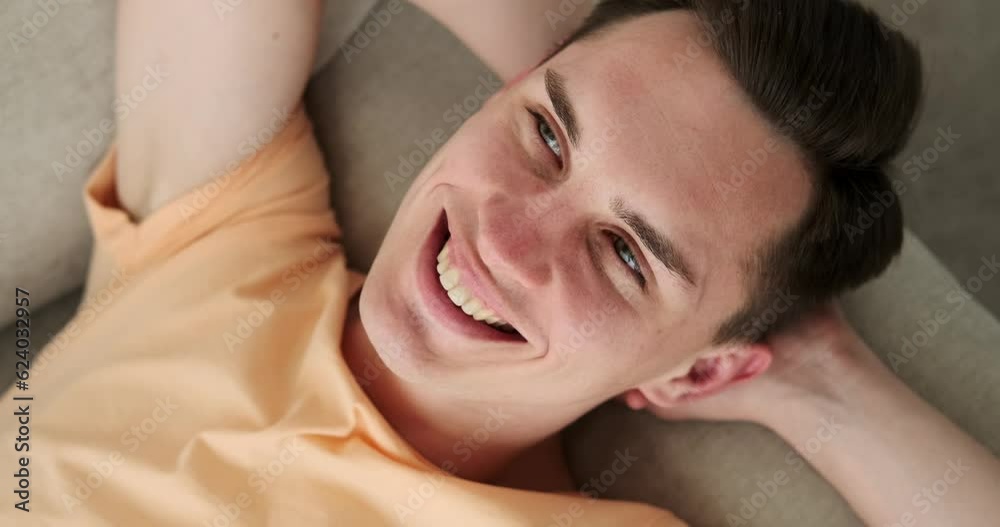 Carefree man in a state of blissful relaxation on the sofa in the living room. With a carefree expression and a relaxed posture, he exudes an aura of ease and tranquility. Carefree man in a state of blissful relaxation on the sofa in the living room. With a carefree expression and a relaxed posture, he exudes an aura of ease and tranquility.