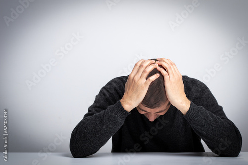 Homeless man drug and alcohol addict sitting alone and depressed feeling anxious and lonely at home. photo