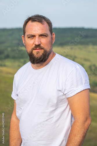 Portrait of a middle-aged brunette man with a thick beard © Andrey_Arkusha