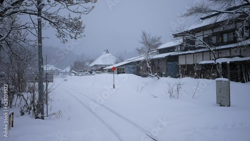 Snow-covered house located in the village next to the railway, snowy winter in the Japan.