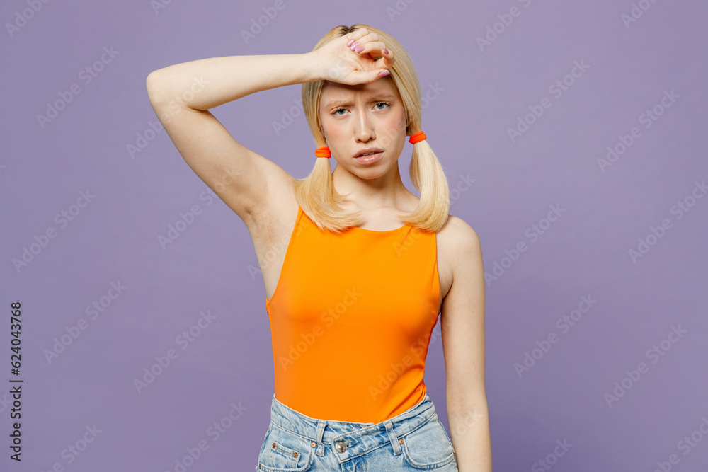 Young sad tired exhausted sick ill blonde woman she wearing orange tank shirt casual clothes put hand on forehead isolated on plain pastel light purple background studio portrait. Lifestyle concept. Young sad tired exhausted sick ill blonde woman she wearing orange tank shirt casual clothes put hand on forehead isolated on plain pastel light purple background studio portrait. Lifestyle concept.