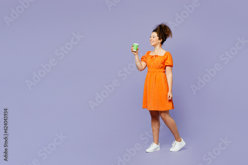 Full body young latin woman she wear orange blouse casual clothes hold takeaway delivery craft paper brown cup coffee to go isolated on plain light purple background studio portrait Lifestyle concept © ViDi Studio