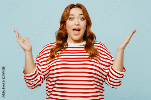Young shocked surprised chubby overweight woman she wears striped red shirt casual clothes spread hands look camera isolated on plain pastel light blue background studio portrait. Lifestyle concept.