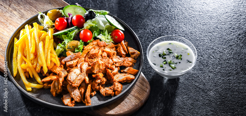 Foto Kebab served with french fries, vegetable salad and tzatziki