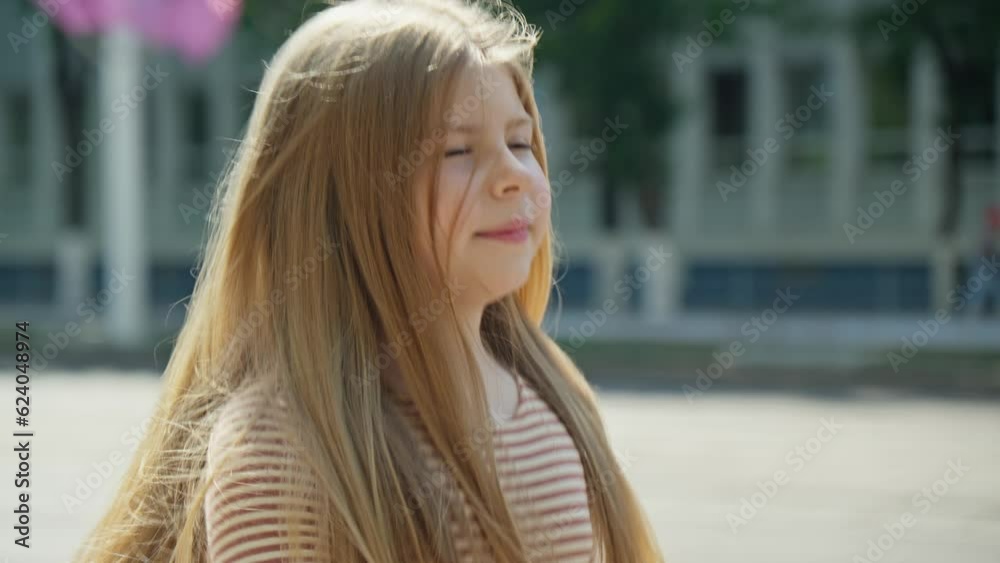 Little girl smiling and looking happy. Beautiful face. Pretty female walking on street in city on summer day. Cheerful portrait at sunny day. 4K, UHD Little girl smiling and looking happy. Beautiful face. Pretty female walking on street in city on summer day. Cheerful portrait at sunny day. 4K, UHD
