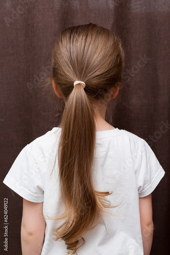 a white elastic band is tied on the girl's hair.