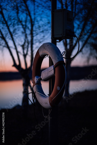 beautiful sunrise with closeup of lifebuoy by water 