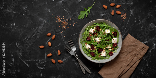 Beetroot salad with arugula and feta cheese. Black stone background. Top view  flat lay. Diet salad.