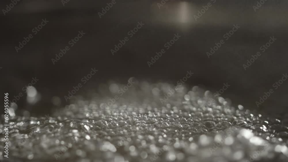 Slow motion water boiling in pot closeup
