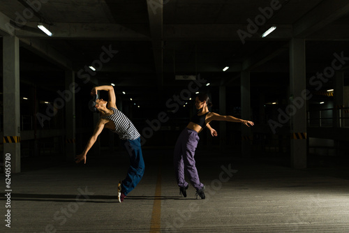 Couple of urban street dancers dancing at night in the garage