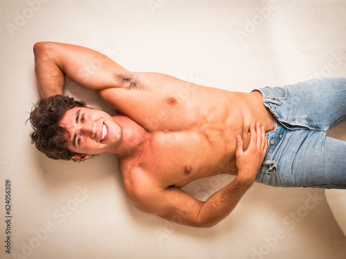 Handsome young bodybuilder laying down on the floor