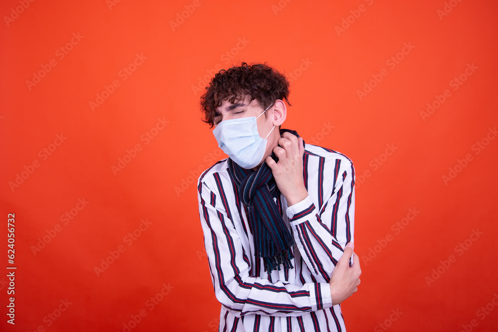 Young attractive emotional guy with health problems posing in the studio on an orange background. Young attractive emotional guy with health problems posing in the studio on an orange background.
