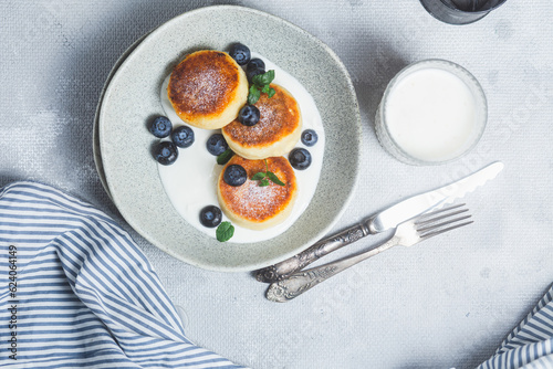 Cottage cheese pancakes with cream sauce and blueberries. syrniki 