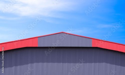 Red gray corrugated Steel Roof Eaves of Modern Warehouse Building against blue sky background