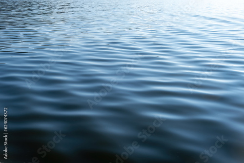 Sea water with small ripple background texture. Ocean surface blue color, empty template, copy space