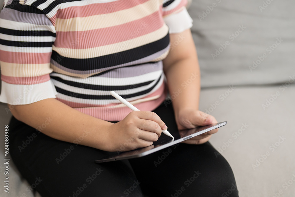 Woman holding a book device reading on e-book on digital tablet device or social media apps online ecommerce. Woman holding a book device reading on e-book on digital tablet device or social media apps online ecommerce.