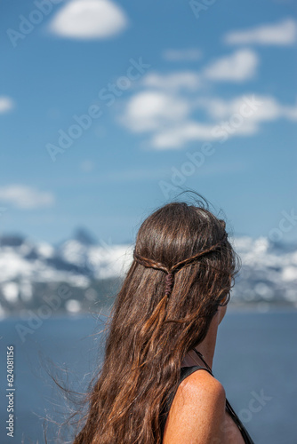 Frau mit Langen Haaren vor einem See im Gebirge