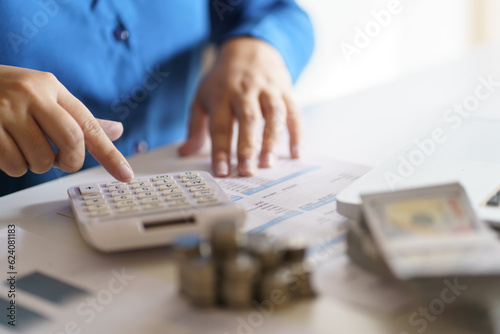 Business woman calculating financial statement on calculator income tax online return and payment.