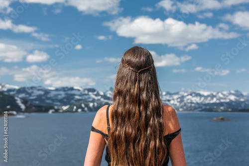 Frau mit langen Haaren  vor einem See im Gebirge