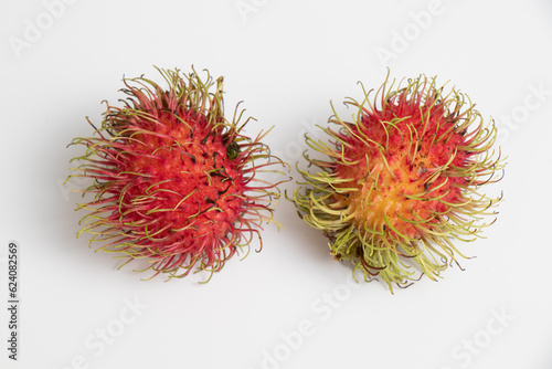 Two rambutan on isolated white background. Red fruit.