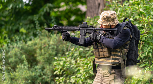A man in military uniform aims at a sight
