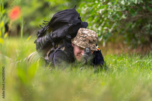 Obraz na płótnie Soldier or mercenary aiming while prone w salonie