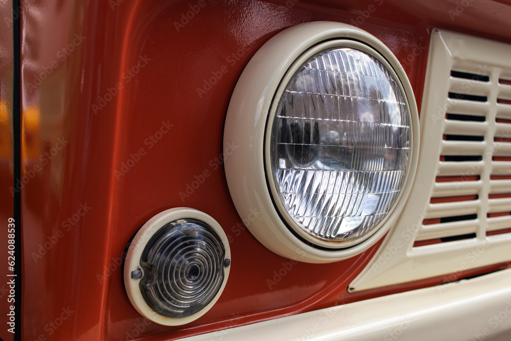 Headlight on a red retro car. Close-up.