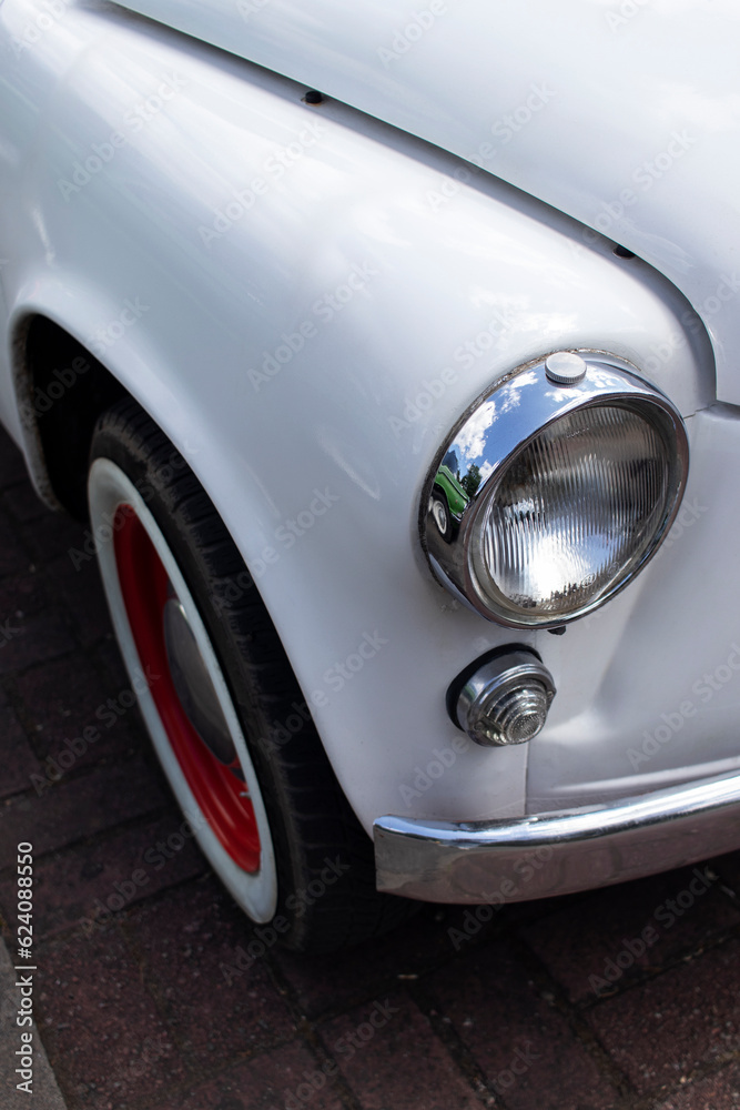 Chrome headlight on a white retro car. Close-up.