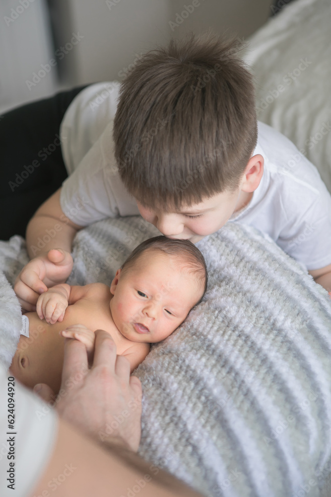 Portrait of father and his four son holding his newborn baby