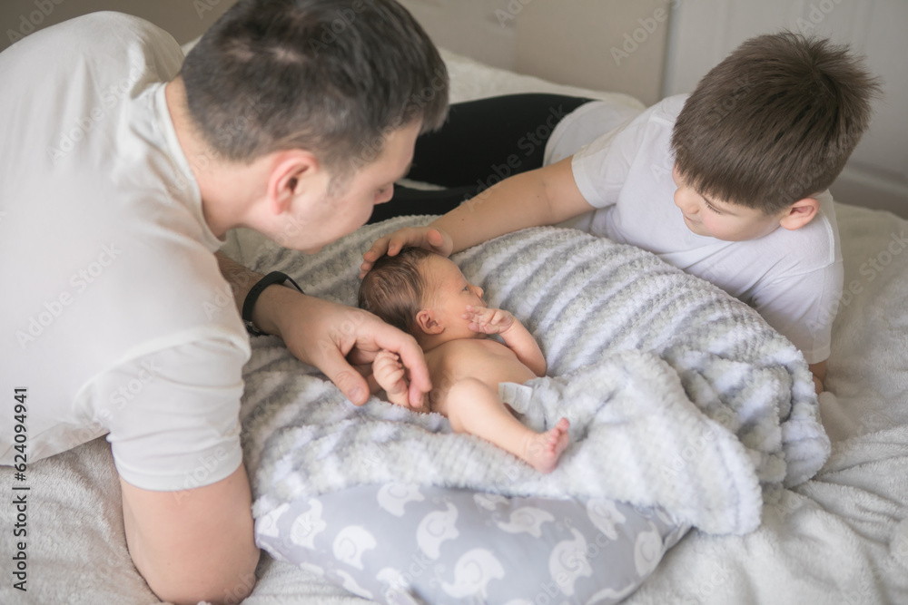 Portrait of father and his four son holding his newborn baby Portrait of father and his four son holding his newborn baby