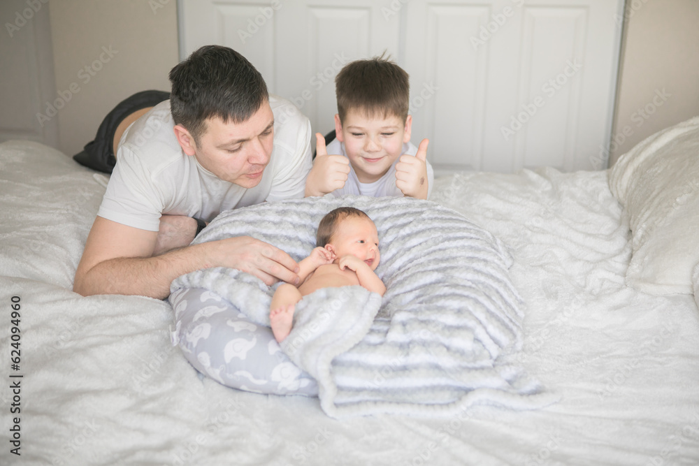 Portrait of father and his four son holding his newborn baby Portrait of father and his four son holding his newborn baby