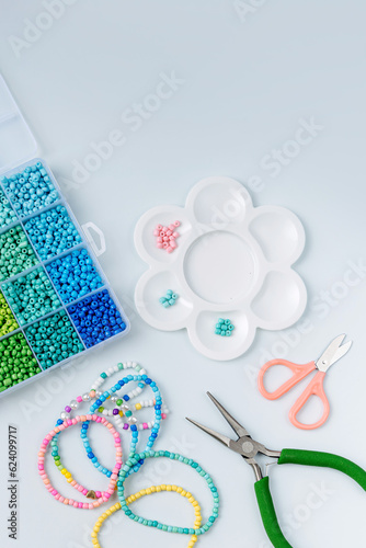 Set of for needlework and beading. Kids handmade beaded jewelry and different multi-colored beads for children's crafts in boxes. DIY art activity for kids. Motor skills, creativity and hobby.