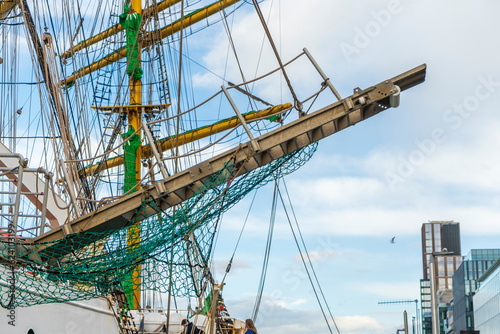 Masts of a sailing ship with blue sky and white clouds