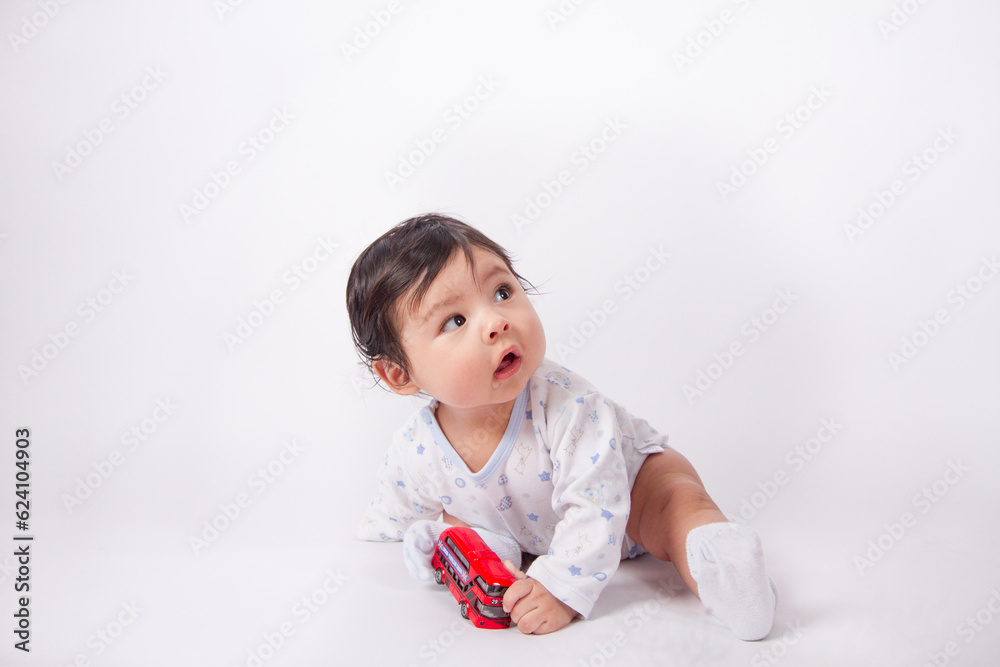 Beautiful photo of baby playing on light background in photo studio. Family and baby concept. Beautiful photo of baby playing on light background in photo studio. Family and baby concept.