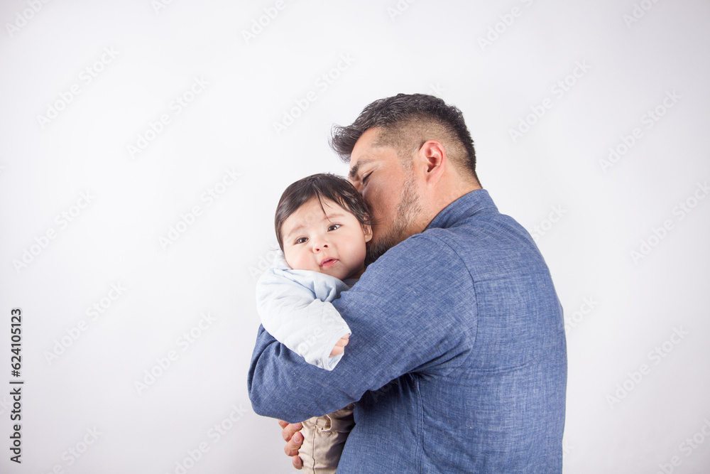 Fototapeta premium Beautiful photo of dad holding baby on light photo studio background. Family and baby concept.