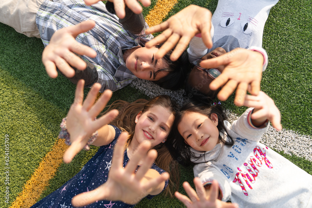 Lovely pupils lying on the grass to play Lovely pupils lying on the grass to play
