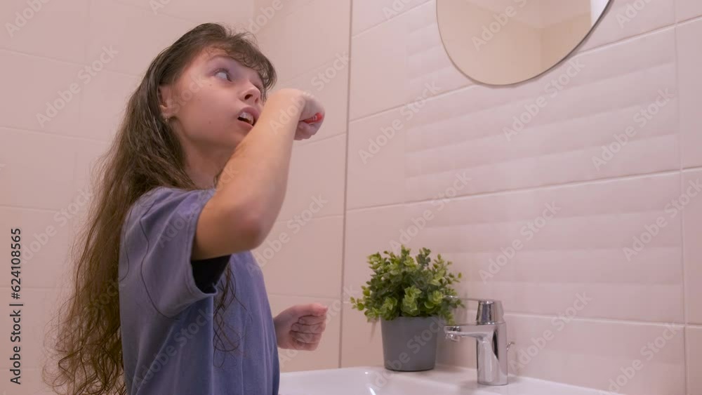 The child brushes his teeth. Cute little girl in the bathroom brushing her teeth. The child brushes his teeth. Cute little girl in the bathroom brushing her teeth.