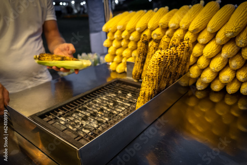 A street vendor roasts corn on a charcoal grill in Istanbul, Turkey. Misir, a popular Turkish street food, is freshly boiled or grilled sweet corn on the cob sprinkled with salt and spices. photo