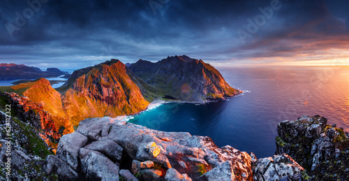Aerial view of rocky shoreline at sunrise with mountains and cliffs